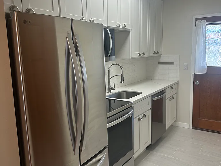 Fully remodeled kitchen showing back door to backyard.