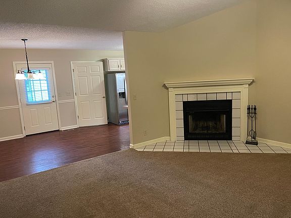 Wood burning fireplace in living room open to dining room.