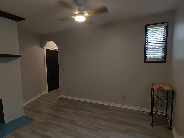 Living room with varnished wood trim and facade fireplace