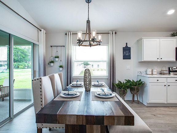 Sunny cafe with doors leading to lanai - New home for sale in Auburndale FL. Photo showcases a