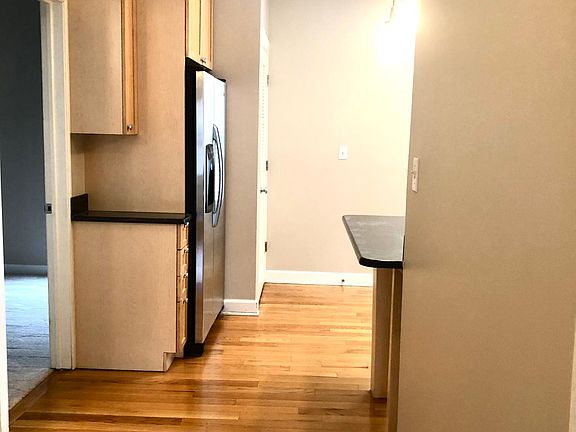 SS refrigerator with water and ice. Breakfast bar features overhead pendant lighting.