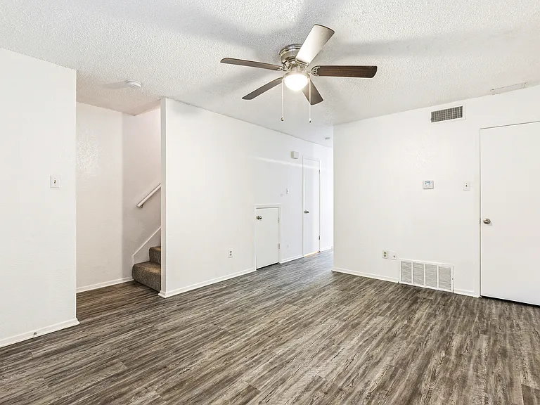Living room with storage closet to the right, .5 bath under the stairs (leading to the kitchen) and stairs to second floor 2 bedrooms and 2 baths.