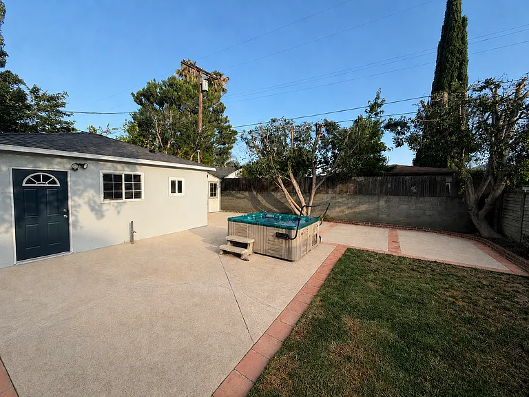 Large fenced backyard with hot tub and entry to office/studio/bonus space with additional bathroom