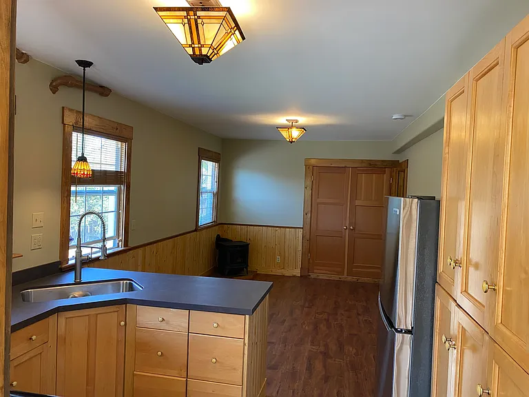 another view of the kitchen and living room with the light on