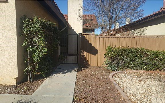 A View of the front of the home with a gate that leads to the front porch & yard area.