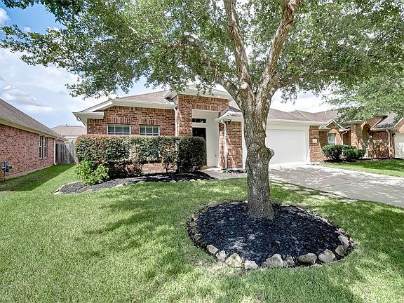 The meticulous front yard boasts lush green lawn with mature shrubs and tree. The driveway offers additional off street parking.