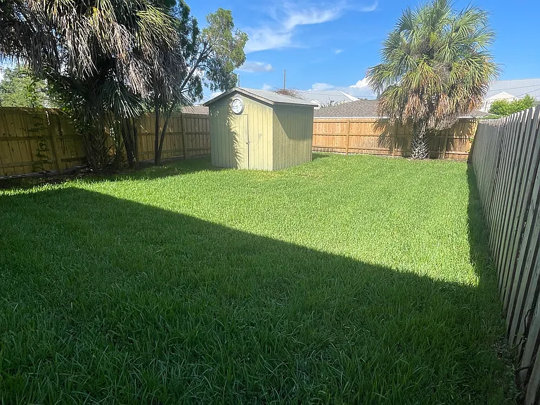 Beautiful and spacious backyard is fully fenced and has a nice paved patio and a shed