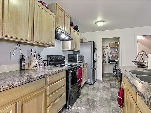View of kitchen from hall entry, you will note large walk-in pantry/mud room leading to garage straight ahead, powder room to your right. 