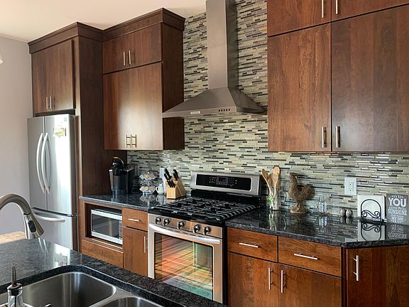 Kitchen with granite counter tops & stainless steel appliances.