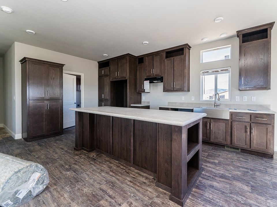 Kitchen - Solid wood cabinets to ceiling, upgraded nickel hardware, title back splashes, highly upgraded stainless appliance package, large center island, and country farm sink with pull-out faucet, recessed lighting.