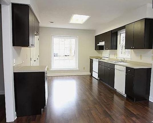 Kitchen includes refrigerator, oven/stove, microwave, dishwasher and looks out to front yard