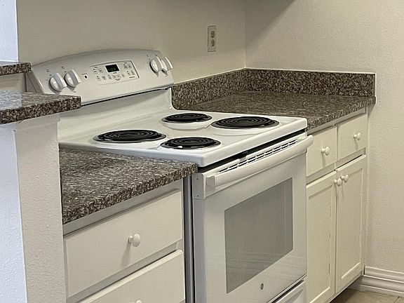 Kitchen with newer GE electric range and granite countertops