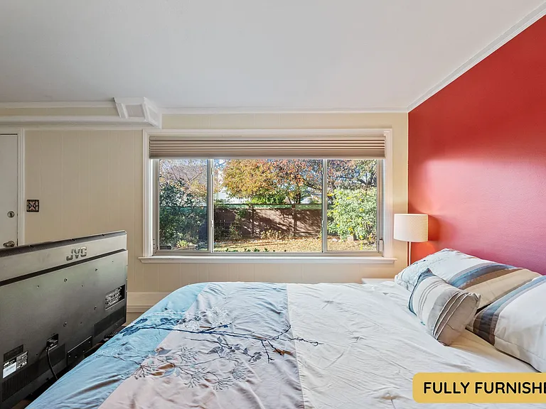 Downstairs is a large bedroom with ensuite full bathroom, queen bed, smart TV, sitting area, wall table, desk & chair, dresser, XL closet, large windows and an exterior door onto the backyard. Also connects to the laundry and bonus space.