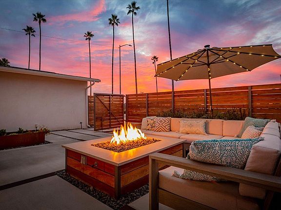 Front patio secured by modern ipe fence featuring gas fireplace.