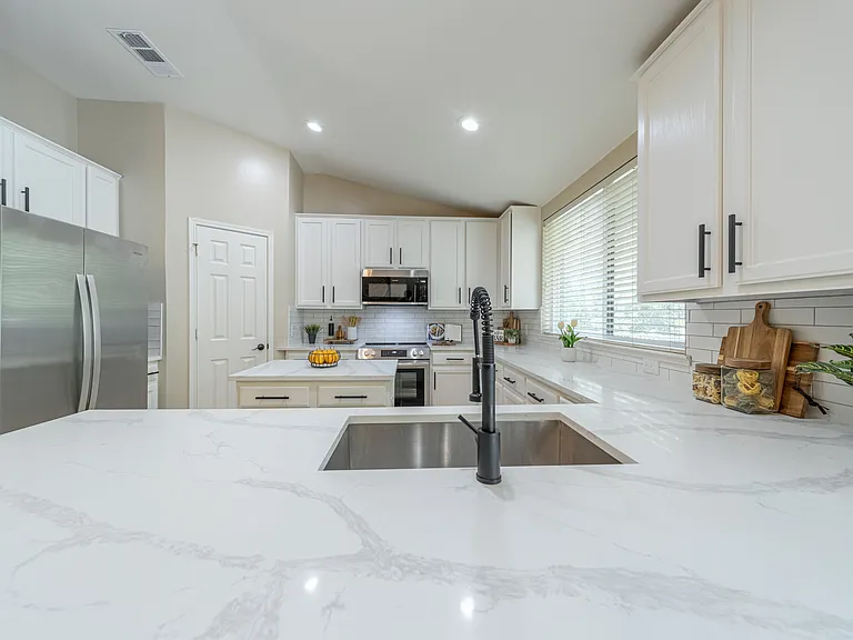 Kitchen view showing stainless steel refrigerator