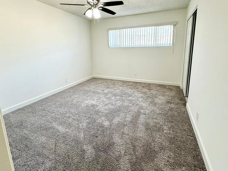 Spacious bedroom with dual pane windows and ceiling fan