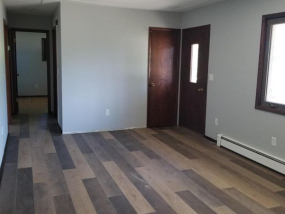 Living room with view of front door and hallway to 3 bedrooms.