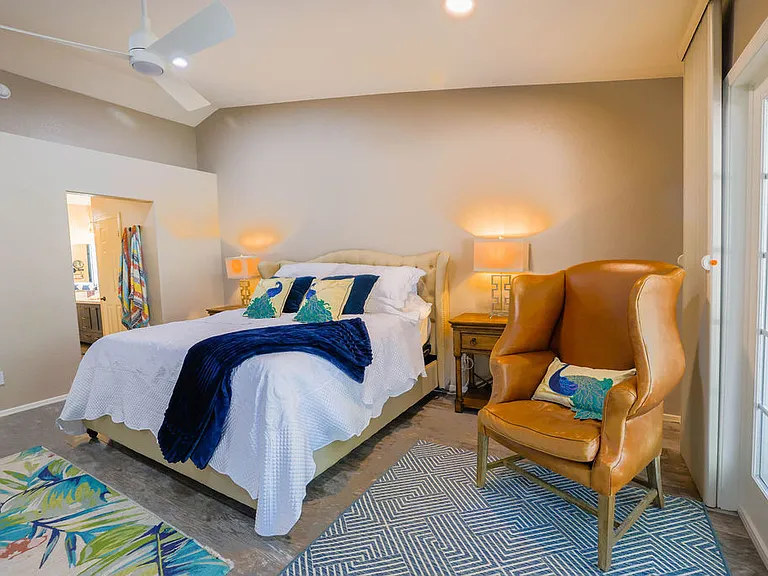 Master suite bedroom with king size adjustable split NECTAR hybrid copper cooling mattress, side tables with outlets, side seating, 60" TV, amoire, dedicated bath, walkin closet, with french doors to back patio