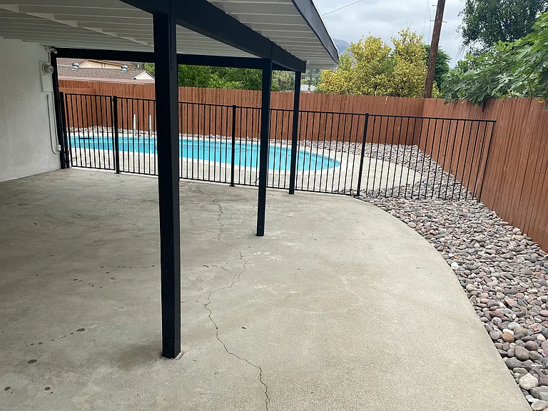 Wrought-iron fence and gate separating the pool area.