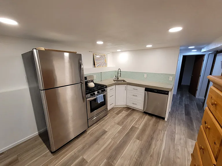 Modern kitchen, gas appliances, and concrete counters.