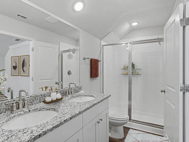 Primary bathroom with double vanity, walk-in shower.