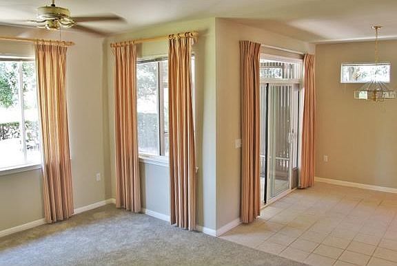 Open living room and kitchen area with view of greenbelt.