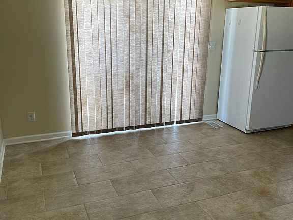 Dining area adjacent to kitchen and family room, with sliders to two-tier back deck for grilling