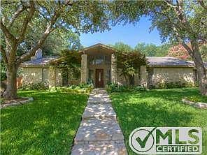 Gorgeous stone single story traditional set a huge tree-shaded