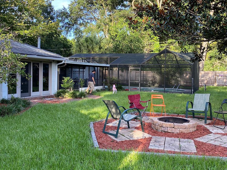 Fenced in backyard with fire pit, fruit trees, screen in pool