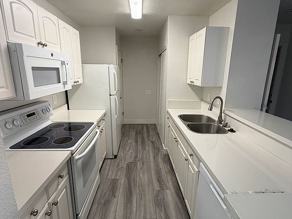spacious clean kitchen with large pantry and washer and dryer closet at the end.