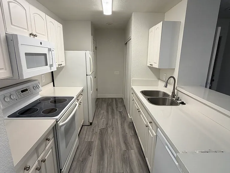 spacious clean kitchen with large pantry and washer and dryer closet at the end.