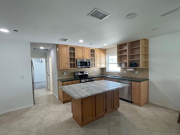 Open living kitchen area with an oversized island. Plenty of cabinet space/