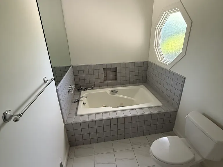 Master bedroom tub, shows lovely tile floor and window