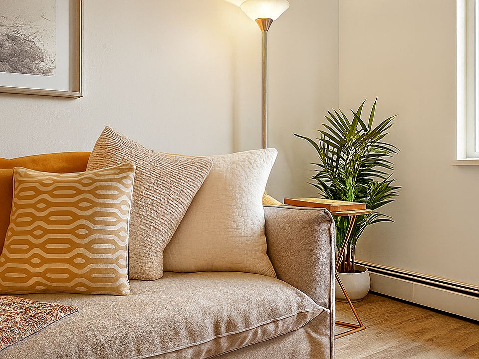 Soft textures, warm lighting, and a leafy touch create the perfect nook to unwind.
