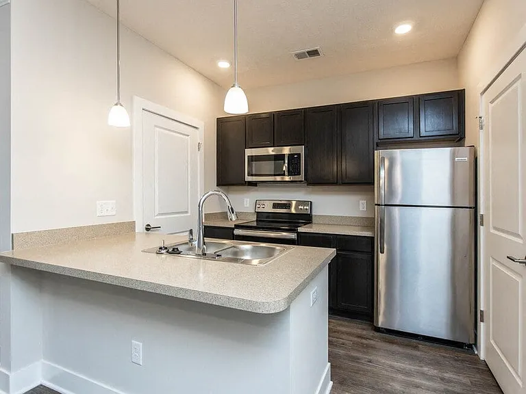 Dooley's Orchard apartment unit showing an updated kitchen with countertops, cabinet, stovetop, oven, and refrigerator.