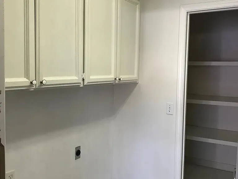 Indoor laundry room with hook ups for washer and dryer.