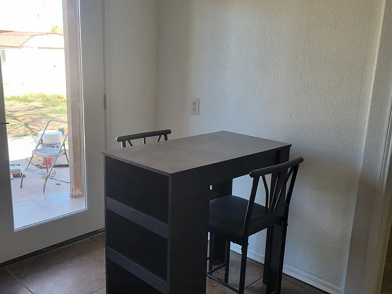 Modern dining table set with two chairs and storage space.