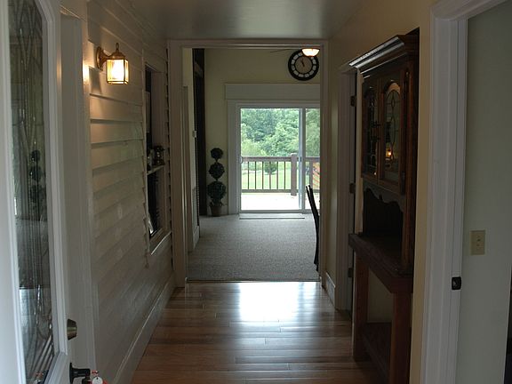 Entrance hall shows original lap-board siding & custom built-in display case