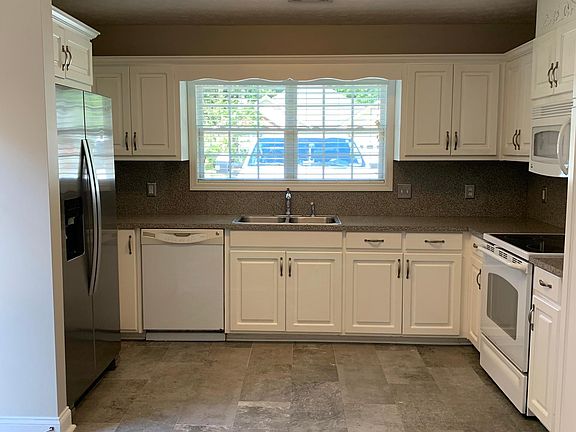 Kitchen with tiled flooring and stainless refrigerator