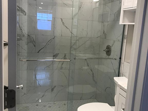 Newly renovated bathroom - floor to ceiling tile in walk-in shower
