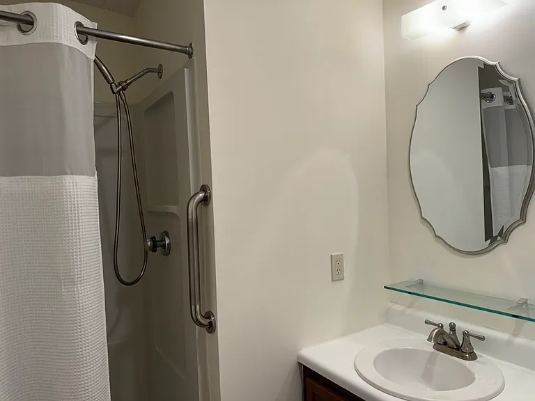 Rain shower 
Grab bar
Curtain with liner and window
Glass shelf for sundries
Framed mirror
Bathroom is vented