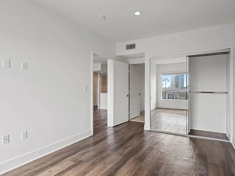 Bedroom with Mirrored Closet, Recessed Lighting, and Vinyl Flooring