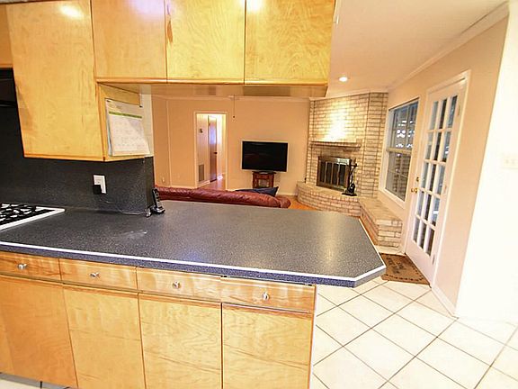Open concept allows the cook to still be involved with what's going on in the den. Door to right acc