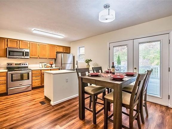 Beautiful cabinetry and stainless steel appliances adorn this bright beautiful natural space.  The door to the deck steps down i