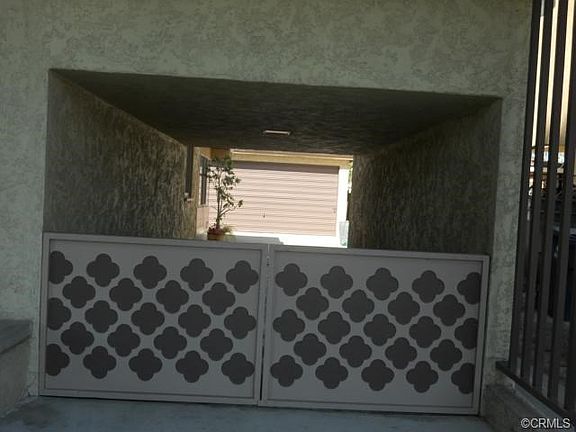 Gated drive thu car port with lighting and storage above.  Cool