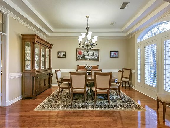 Elegant formal dining room boasts chair-rail molding, gleaming hardwoods and custom ceiling treatment.