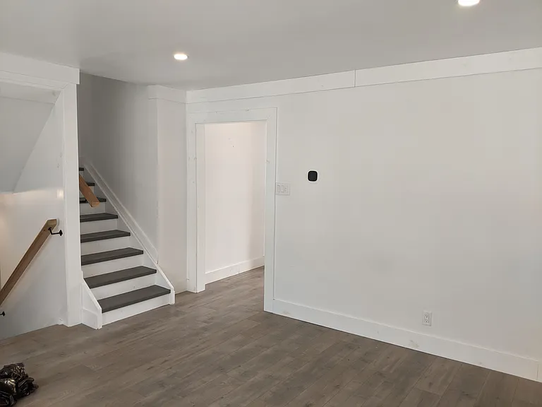 Living Room showing stairs down to the main floor and stairs up to the three bedrooms and main bathroom.