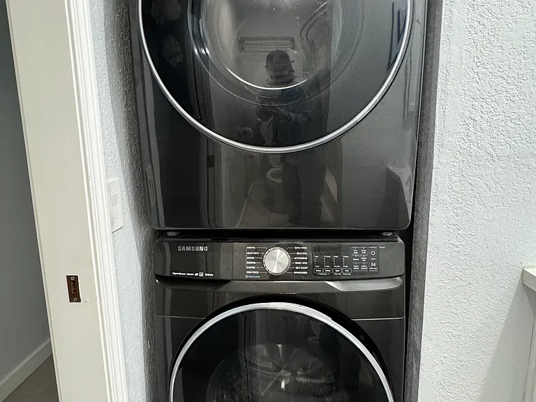 Recently renovated guest bathroom with bathtub, in unit washer and dryer and tile flooring.