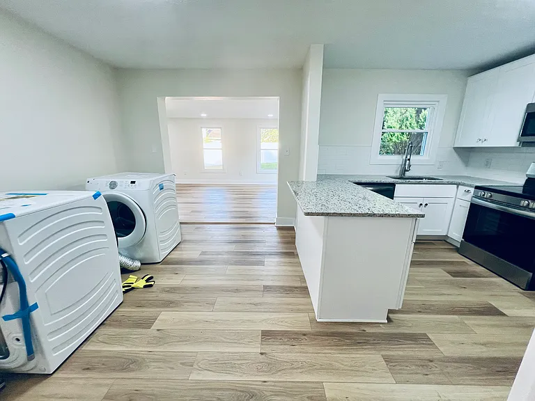 Kitchen, dining room, leading to sunroom addition. (Washer/dryer to be installed in garage)