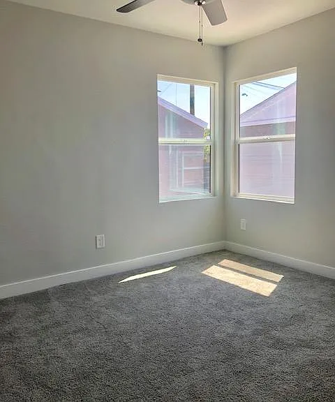 Bedroom 2 with new ceiling fan, new windows, new carpet, new paint